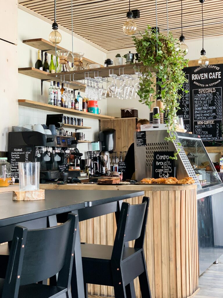 Contemporary cafe with wooden accents and hanging plants, offering a warm, inviting atmosphere for coffee lovers.